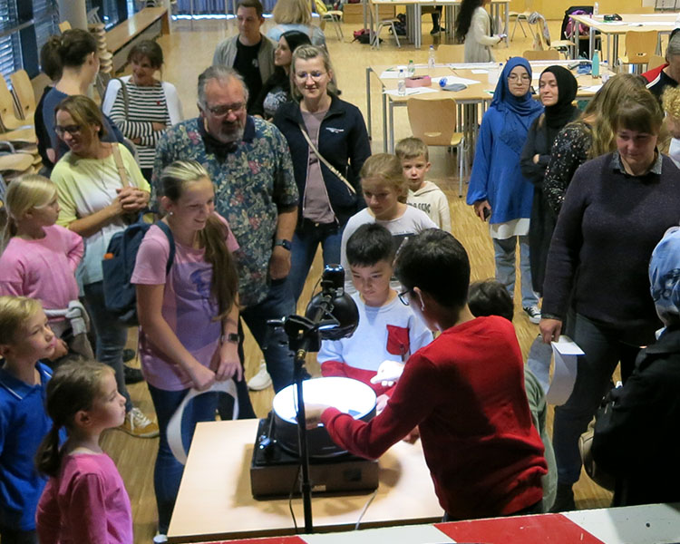 Participants presenting their self-made animation on a praxinoscop during a Zoetrope workshop, hold by Thomas Stellmach.