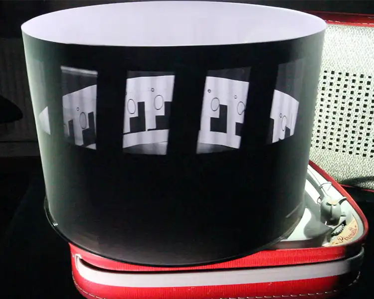 A zoetrope is a pre-film animation device that produces the illusion of motion, by displaying a sequence of drawings or photographs showing progressive phases of that motion.