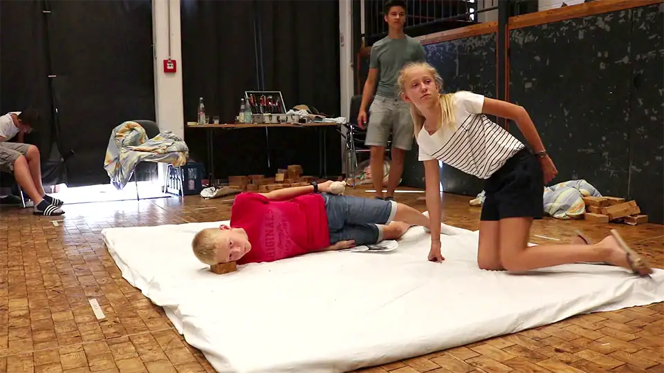 Pixilation-Workshop-2010-film-shoot-collaboration Young participants in a pixilation workshop: Two performers pose in different body positions on a white mat for a stop-motion animation.